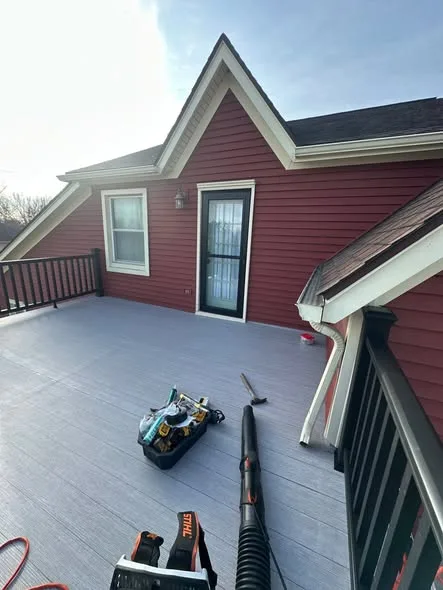 Completed balcony waterproofing with gray composite decking and black railing
