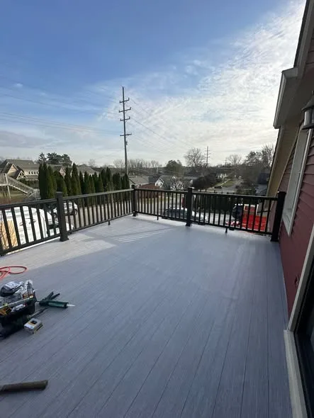 View from newly waterproofed balcony deck showing black railing and neighborhood