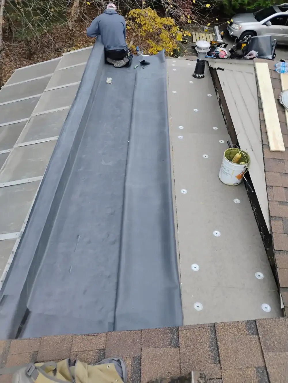 Metro Detroit Flat Roof crew rolling out EPDM rubber membrane on a residential flat roof, Oakland County Michigan
