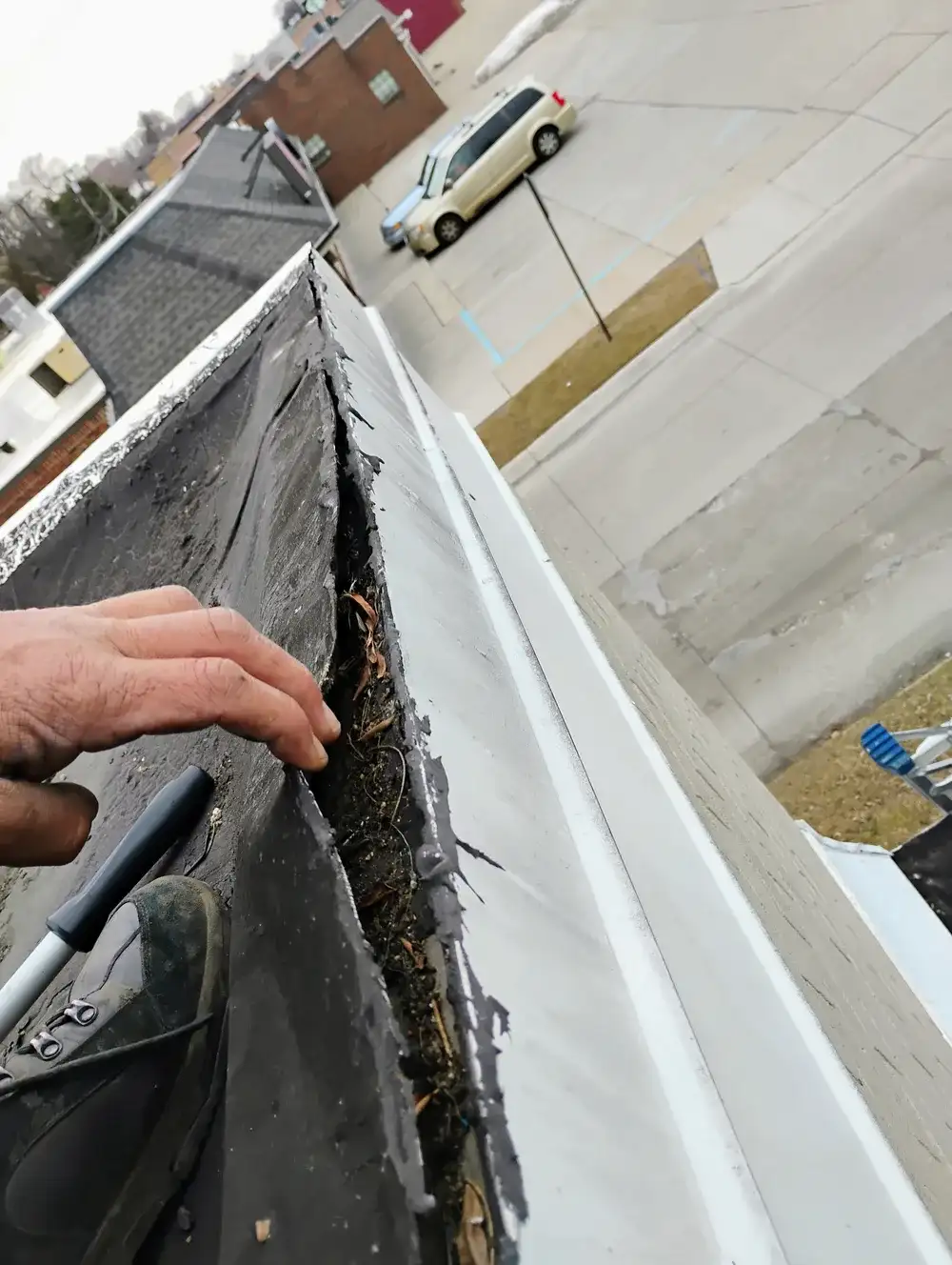 Aerial view of flat roof section beside pitched shingle roof showing installation in progress