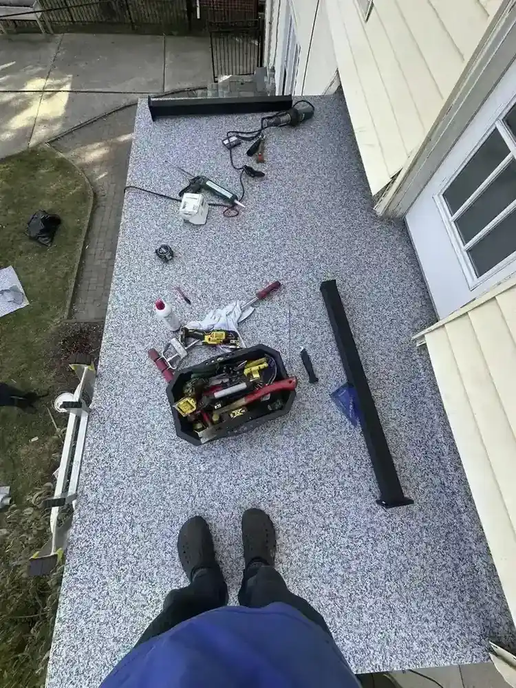 Top-down view of flat roof work in progress with tools