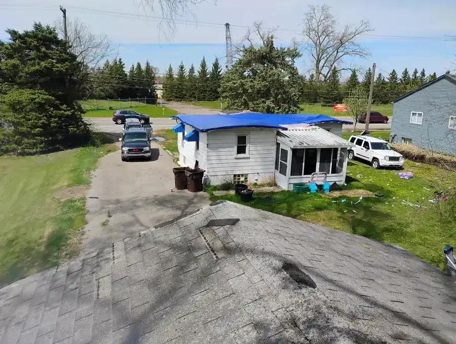 Emergency tarp installation on an actively leaking flat roof